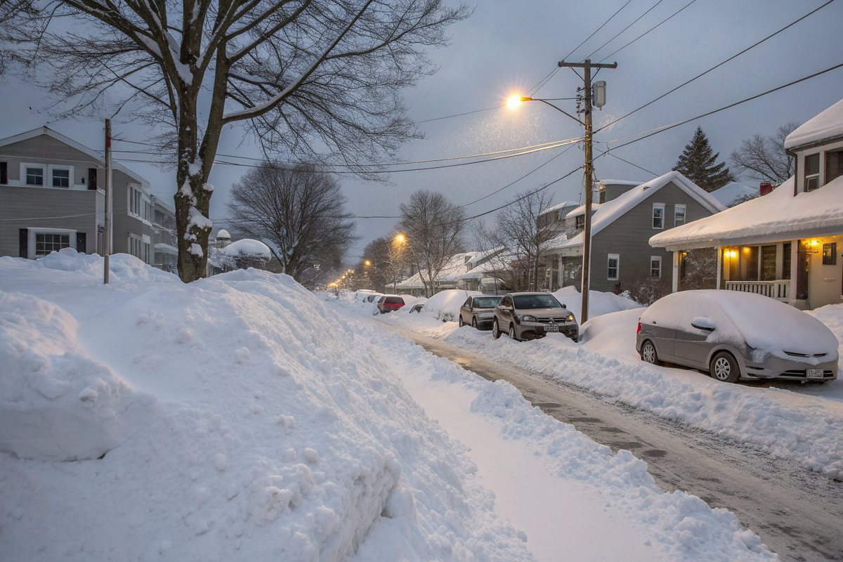 Heavy lake-effect snow falling on a street of snow-covered houses
